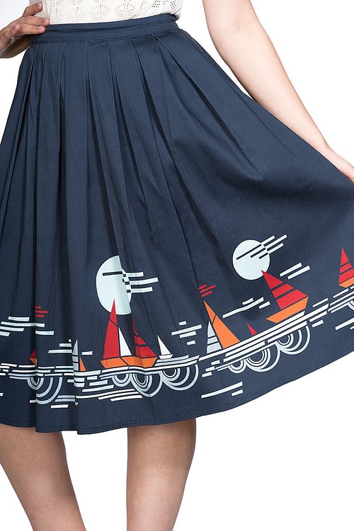 Charmerende og super klassisk retro-inspireret 50’er nederdel med læg i flot navyblå med print af sejlskibe