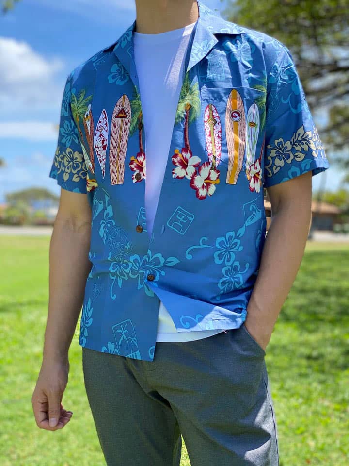Lækker ægte Hawaiiskjorte, 100% bomuld blå med hibiscus, hawaiimotiver og en række surfboards.