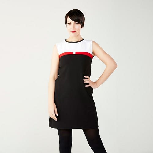 Den klassiske Mod kjole i 1960’er stil - sort med hvid top og et rødt bånd over brystet med en hvid blomsterknap
