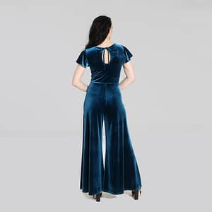 Mischa er en smuk vintage-inspireret jumpsuit i flot petroleumsblå velour og med draperet v-udskæring, korte ærmer og brede bukseben.