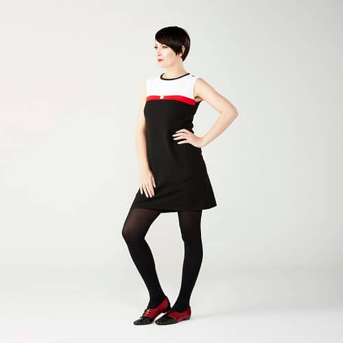Den klassiske Mod kjole i 1960’er stil - sort med hvid top og et rødt bånd over brystet med en hvid blomsterknap