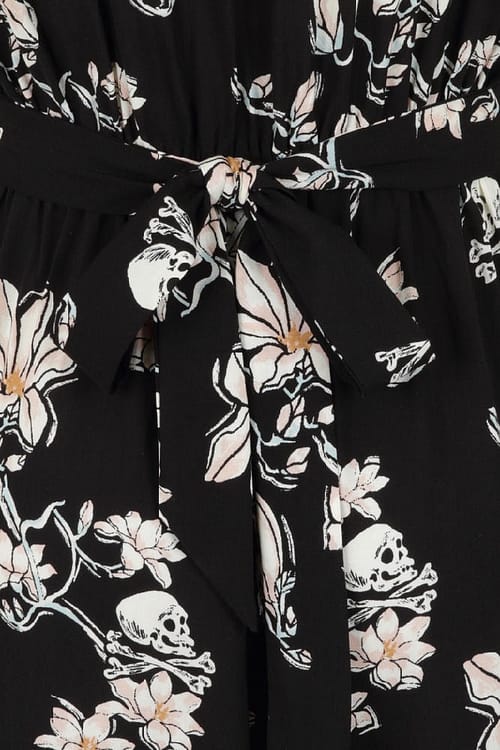 Jumpsuit i viscose med print af skulls og blomster på sort baggrund, den har cap-ærmer og lommer foran